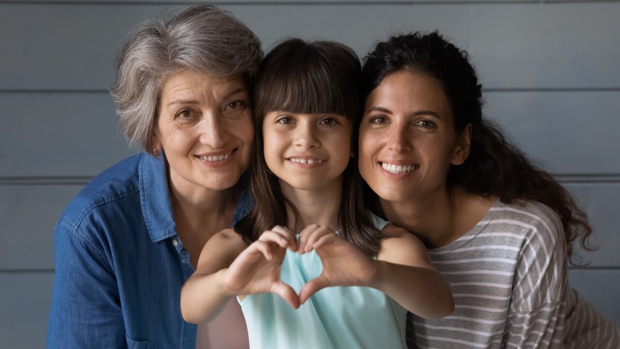 family with kid doing heart hands